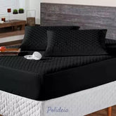 protetor de colchão impermeável matelado preto sobre uma cama de casal